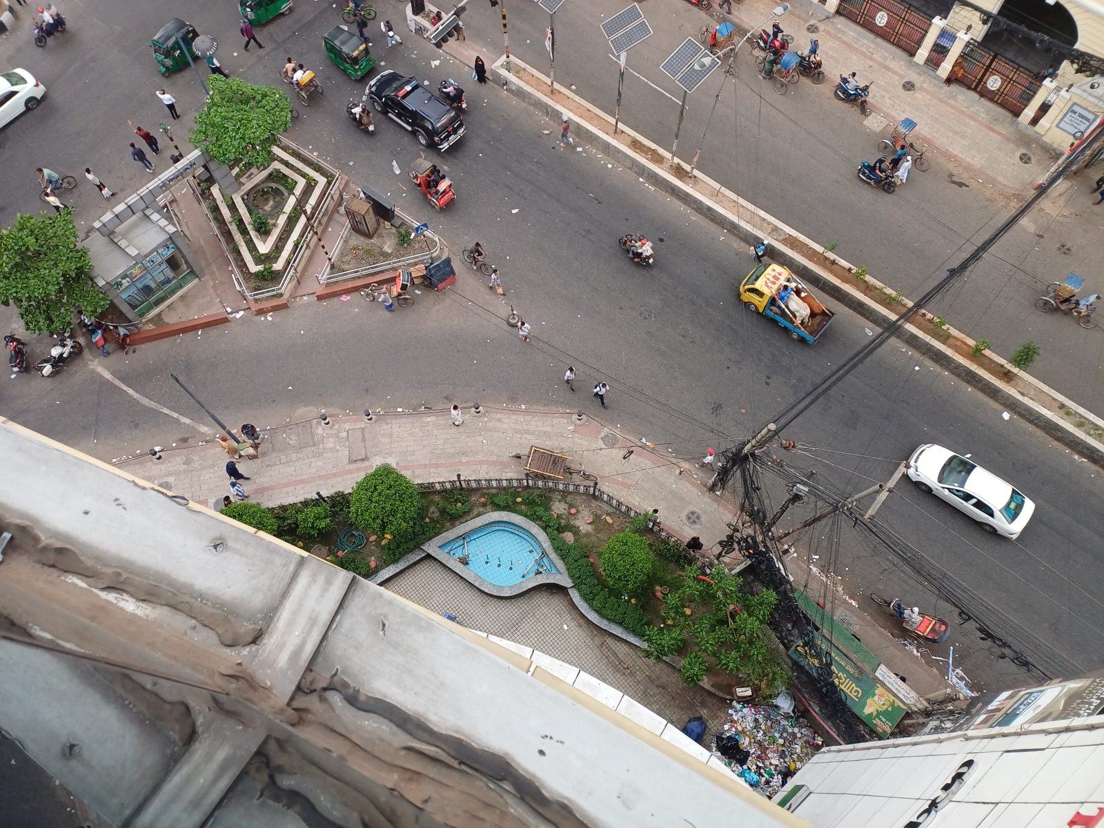 Junction in old Dhaka seen from a rooftop, with boxes around people, cars, CNG auto-rickshaws, rickshaws, motorbikes, bicycles and a pickup